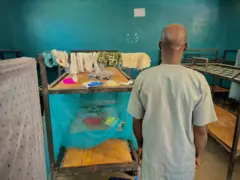 Un homme photographié de dos, dans un dortoir d'élèves de l'école catholique Sainte-Marie de Papiri, dans la zone de gouvernement local d'Agwarra, État du Niger.