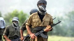 صفی از چریک‌های کرد با اسلحه در دست و صورت‌های پوشیده