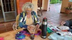 Mulher bordando sobre uma mesa