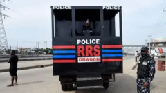 Police Rapid Response Squad RRS officer stand near RRS truck truck