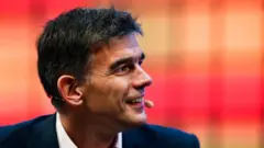 Метт Бріттін у костюмі на червоногарячому тлі