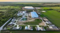 El sitio fotografiado en 2023, con las instalaciones de SpaceX en la parte superior, The Boring Company a la izquierda y el edificio que alberga negocios locales en el centro. 
