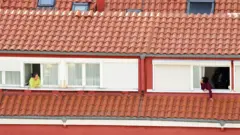 Duas vizinhas conversando pela janela de seus respectivos apartamentos