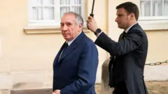 François Bayrou marchant sous un parapluie