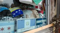 Uma bandeira de El Salvador e uma da Guatemala na vitrine de uma loja.