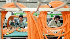 Trabajadoras en una planta de fabricación de autos eléctricos en China
