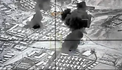 Siyah beyaz fotoğrafta yerleşim yerlerinden duman çıktığı görülüyor