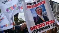 Pessoas segurando cartazes em apoio às reformas de Petro