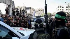 Anggota Hamas menyerahkan sebagian dari 20 sandera Israel kepada tim Komite Palang Merah Internasional (ICRC) sebagai bagian dari gencatan senjata dan perjanjian pertukaran sandera-tahanan antara Hamas dan Israel pada 13 Oktober 2025.