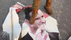 پوستر پاره شده بشار اسد