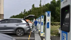 Hombre cargando un vehículo eléctrico en una de las estaciones públicas de recarga