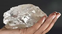 Mão segurando um grande diamante