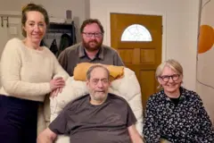 Pai sentado em cadeira posa com esposa e filhos para sua última foto antes de morrer