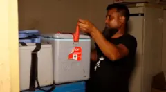 হামের টিকা ব্যবস্থাপনায় নিয়োজিত একজন কর্মীকে দেখা যাচ্ছে।