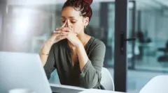 Umugore ubabaye wicaye imbere y'imashini