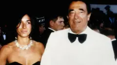 Robert Maxwell con traje blanco y corbatín negro y su hija, con un collar birllante y vestido negro.