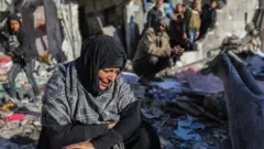 A woman cries as she looks at the devastation around her