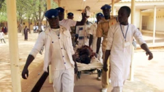 Awọn oṣiṣẹ eleto ilera to wọ aṣọ funfun n gbe alailera lọ sibi kan nile iwosan 