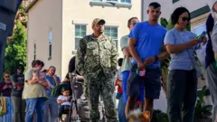 Военнослужащий ВМС США стоит в очереди среди военнослужащих, чтобы получить бесплатную еду от волонтеров продовольственного банка Feeding San Diego 24 октября 2025 года в Сан-Диего, Калифорния.