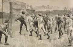 Hombres con pantalones hasta debajo de la rodilla, medias altas y camisas de rayas verticales, unos, y camisas blancas, otros, en un campo de fútbol. Un jugador frente a la portería cabecea el balón y el arquero está atento. Un árbitro con una gorra y un banderín está atento a la jugada