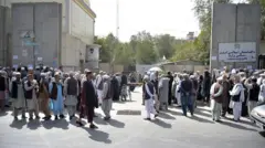 شماری از مردان متقاعد در افغانستان که پشت مستوفیت وزارت مالیه حکومت طالبان تجمع کرده اند.