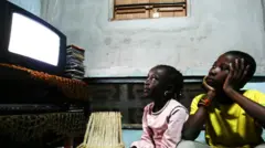 Crianças assistindo à televisão na África