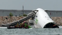 Ọkọ ofurufu akẹru ninu omi okun pẹlu awọn oṣiṣẹ pajawiri to n gbiyanju lati doola ẹmi awọn eeyan.