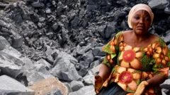 Rock blasting site for background while a woman dey stay for front