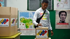 Un hombre con una camiseta blanca vota en una urna que dice "CNE Poder Electoral".