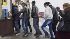 Moskvadagi migrantlarni ro‘yxatga olish markazi binosi ichiga kirib borayotgan markaziy osiyoliklar
