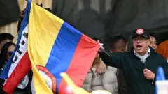 O presidente colombiano Gustavo Petro agita uma bandeira do seu país durante um discurso em uma manifestação comemorativa do Dia do Trabalho em Bogotá, no dia 1º de maio de 2024