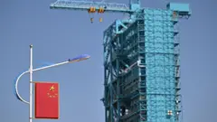 Ракета-носитель Long March-2F с космическим кораблем «Шэньчжоу-20» в строительных лесах на стартовой площадке за день до запуска корабля «Шэньчжоу-20» в Центре запуска спутников Цзюцюань в пустыне Гоби на северо-западе Китая 