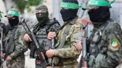 Gunmen stand guard at the funeral of Marwan Issa, a senior Hamas deputy military commander who was killed in an Israeli airstrike during the conflict between Israel and Hamas, amid a ceasefire between Israel and Hamas, in the central Gaza Strip, February 7, 2025. REUTERS/Ramadan Abed/File Photo