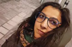 Foto de Vitória, usando óculos e um cachecol colorido