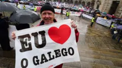 Manifestante segura cartaz com a frase 'Eu amo o galego' durante ato na cidadechat betmotionSantiagochat betmotionCompostela, na Galícia,chat betmotiondefesa da promoção e da preservação da língua galega