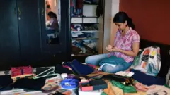 Woman checks mobile while organising wardrobe