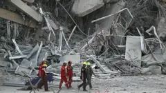 Рятувальники проходять повз уламки будівельного майданчика після того, як будівля обвалилася в Бангкоку 28 березня 2025 року після землетрусу.