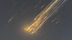 空中分解したスペースXの宇宙船がオレンジ色に光り落下する様子。マーカス・ハワースさん撮影動画より（16日、タークス・カイコス諸島）