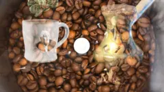 Ọpọ eso Coffee ati ife kan ni aarin rẹ