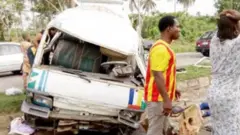 Bọọsi kan run jege tori ijamba ọkọ, awọn eeyan mẹrin duro yika rẹ