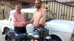 Arun Srinivasan, right, with his father after bringing the beloved motorbike home