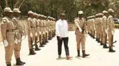 Minisitiri w’umutekano mu Rwanda, Vincent Biruta (wambaye ishati y’umweru), atambuka mu karasisi k’abacungagereza ya Rwamagana ubwo yari yayisuye muri Nzeri(9) uyu mwaka