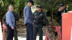 Policiais em frente a uma casa