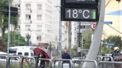Foto de um termômetro de rua marcando a temperatura de 18 graus.