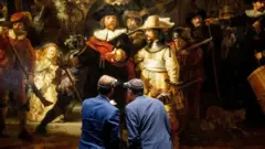 Generalni direktor Rajksmuzeja Tako Dibits (levo) i Tijeri Vanlanker, generalni direktor kompanije AkzoNobel (levo) stoje ispred Rembrantove slike u Amsterdamu