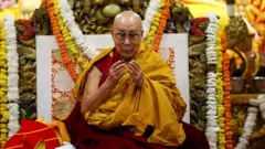 达赖喇嘛坐在一座以花卉环绕装饰的宝座上。他剃着光头，戴着眼镜，身穿酒红与金色相间的僧袍，低头看着自己的双手