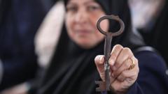 Una mujer palestina muestra una llave.