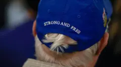 Потилиця чоловіка в кепці, на якій написано strong and free.