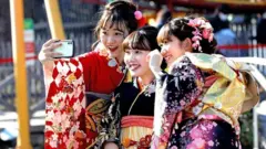 'Yan matan da suka kai shekarun budurci cikin kwalliyar kayan gargajiya na Japan, su na daukar hoton dauki da kan ka