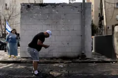 يتفقد أشخاص آثار قصف صاروخي وقع في اليوم السابق، وأسفر عن مقتل رجل واحد وإصابة شخص آخر إصابته خطرة، وذلك في 27 مارس/ آذار 2026 في مدينة نهاريا شمالي إسرائيل.